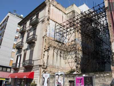 Qui infatti permane da decenni una strana situazione: un palazzo abbattuto (mai sostituito da un edificio di nuova costruzione) ha creato uno spazio perennemente puntellato da sostegni in ferro